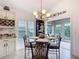 Elegant dining area with a chandelier and views to the lanai at 383 Harlow Ln, The Villages, FL 32163