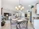 Chic dining area featuring elegant chandelier and views to the living room and kitchen at 383 Harlow Ln, The Villages, FL 32163