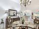 Dining room features a glass-top table with seating, chandelier, and buffet with decorative mirror at 383 Harlow Ln, The Villages, FL 32163