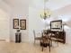 Cozy dining area featuring a glass-top table, chandelier, and stylish decor at 383 Harlow Ln, The Villages, FL 32163
