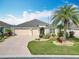 Charming single-story home with a well-manicured lawn, mature landscaping, and a three-car garage at 383 Harlow Ln, The Villages, FL 32163