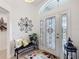 Inviting foyer with a decorative glass front door, bench, and an arched transom window at 383 Harlow Ln, The Villages, FL 32163