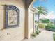 Elegant front entryway featuring a decorative sconce, bench, and view of the landscaped lawn at 383 Harlow Ln, The Villages, FL 32163