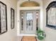 Elegant front entryway featuring a decorative glass door with sidelights and decorative sconces at 383 Harlow Ln, The Villages, FL 32163