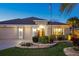 Charming home featuring a three-car garage, beautiful landscaping and manicured lawn at 383 Harlow Ln, The Villages, FL 32163