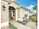 Close-up of home's front porch area with seating, manicured landscaping, and inviting entrance at 383 Harlow Ln, The Villages, FL 32163