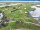Aerial view of a well-manicured golf course with water features, golf carts, and lush landscaping at 383 Harlow Ln, The Villages, FL 32163