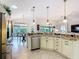 Modern kitchen with stainless steel appliances, granite counters, and a view of the dining area at 383 Harlow Ln, The Villages, FL 32163