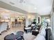 Inviting living room with wicker furniture and seamless access to a modern kitchen with stone countertops at 383 Harlow Ln, The Villages, FL 32163