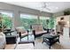 Cozy sunroom filled with natural light, wicker furniture, and serene views of the landscaped yard at 383 Harlow Ln, The Villages, FL 32163