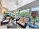 Cozy sunroom with wicker furniture, ceiling fan, and serene outdoor views at 383 Harlow Ln, The Villages, FL 32163