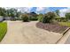 Long driveway leading to a single-story home with mature landscaping and a truck parked on the side at 4420 Ne 1St St, Ocala, FL 34470