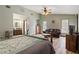 Open-concept main bedroom offers an ensuite bath, laminate flooring, and comfortable furnishings at 4420 Ne 1St St, Ocala, FL 34470
