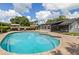Large inground pool with brick surround, screened lanai, and well-maintained landscaping at 4420 Ne 1St St, Ocala, FL 34470