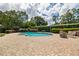 Backyard oasis features a kidney shaped pool, brick paver patio, and mature landscaping at 4420 Ne 1St St, Ocala, FL 34470