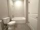 Bright bathroom featuring a tiled shower-over-tub with neutral wall colors and light gray wood-look flooring at 4501 Sw 110Th Ln, Ocala, FL 34476