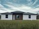 New construction, single-story home featuring white walls, a modern wood accent, and a well-manicured lawn at 4501 Sw 110Th Ln, Ocala, FL 34476
