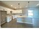 Modern kitchen features white cabinets, a large island, pendant lighting, and sliding doors to the outdoors at 4501 Sw 110Th Ln, Ocala, FL 34476
