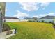 Spacious, well-maintained backyard featuring lush grass, a privacy fence, and mature landscaping at 503 Verlander St, The Villages, FL 34762