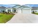 Beautiful exterior of a light blue house with a well-maintained lawn and a spacious driveway at 503 Verlander St, The Villages, FL 34762