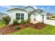 Landscaped front yard featuring lush green grass and meticulously arranged mulch beds with shrubs at 503 Verlander St, The Villages, FL 34762