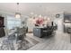 Kitchen and dining area featuring elegant lighting, island seating, and stainless appliances at 503 Verlander St, The Villages, FL 34762