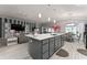 Open concept kitchen and living area with large island, stainless steel appliances, and dining space at 503 Verlander St, The Villages, FL 34762