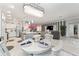 A open living space with a dining area that flows seamlessly into the kitchen and lounge area with large windows at 503 Verlander St, The Villages, FL 34762