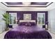 The main bedroom features a luxurious purple color scheme, decorative ceiling, and ample natural light at 503 Verlander St, The Villages, FL 34762