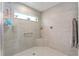 Tiled shower with a glass enclosure, convenient grab bar, and built-in corner shelf at 503 Verlander St, The Villages, FL 34762