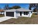 Charming home with gray roof, gray garage door, and a light gray stucco exterior and walkway at 509 Marion Oaks Trail, Ocala, FL 34473