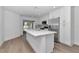 Well-lit kitchen with white cabinets, a spacious island, stainless steel appliances and wood-look floors at 509 Marion Oaks Trail, Ocala, FL 34473