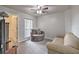 Bedroom features a window with blinds, ceiling fan, a lounge chair, and a neutral color scheme at 5902 Sw 112Th Place Rd, Ocala, FL 34476