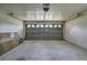 Empty two car garage features a gray door, white cinder block walls and smooth concrete floor at 5902 Sw 112Th Place Rd, Ocala, FL 34476