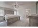 Serene main bedroom boasts a king-sized bed, soft carpeting, and an en-suite bathroom entrance at 5902 Sw 112Th Place Rd, Ocala, FL 34476