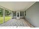 Back patio features gray tile flooring, a gray exterior, and a white patterned rug at 5902 Sw 112Th Place Rd, Ocala, FL 34476