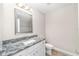 Bathroom with a single granite sink and tiled mirror at 5910 Sw 111Th Place Rd, Ocala, FL 34476