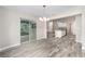 Open floor plan with gray wood floors and dining room featuring sliding glass doors for plenty of natural light at 5910 Sw 111Th Place Rd, Ocala, FL 34476