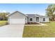 Charming single-story home featuring a two-car garage, landscaped front yard, and neutral stucco exterior at 5910 Sw 111Th Place Rd, Ocala, FL 34476