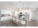 Modern kitchen featuring white cabinets, granite countertops, stainless steel appliances, and a spacious island with seating at 5910 Sw 111Th Place Rd, Ocala, FL 34476