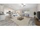 Open-concept living room with neutral tones, modern furnishings, and seamless flow into the kitchen and dining areas at 5910 Sw 111Th Place Rd, Ocala, FL 34476