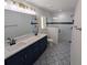 Updated bathroom with double sinks, decorative tile floor, and glass-enclosed shower at 6276 Nw 65 Nw Pl, Ocala, FL 34482