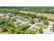 Wide aerial view of a peaceful residential area, green fields, and single-Gathering homes surrounded by trees at 6279 Se 8Th Lane, Ocala, FL 34472