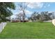 Expansive backyard with lush green grass, a white vinyl fence, and mature trees, creating a private oasis at 6279 Se 8Th Lane, Ocala, FL 34472
