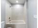 Well-lit bathroom showcasing a tub with marble-like tiling and a shower head at 6279 Se 8Th Lane, Ocala, FL 34472