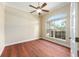 Well-lit bedroom with hardwood flooring, large arched window, ceiling fan and neutral wall color at 6279 Se 8Th Lane, Ocala, FL 34472
