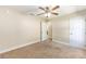 Cozy bedroom featuring neutral carpet, ceiling fan, white trim, and doorways to other rooms at 6279 Se 8Th Lane, Ocala, FL 34472