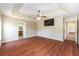 Spacious main bedroom featuring a tray ceiling, ceiling fan, and hardwood floors at 6279 Se 8Th Lane, Ocala, FL 34472