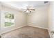 Inviting bedroom with a window for natural light, plush carpeting, ceiling fan, and neutral paint at 6279 Se 8Th Lane, Ocala, FL 34472