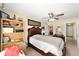 Cozy bedroom featuring a wooden bed frame, ceiling fan, and decor displayed on a bookshelf at 6279 Se 8Th Lane, Ocala, FL 34472